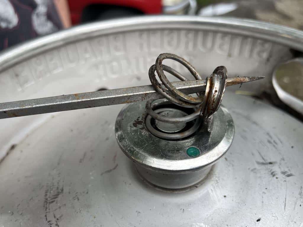 Tearing out the retaining ring in a keg spear with a screwdriver.